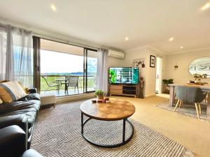 a living room with a couch and a table at Gosfords Best Location with Views in Gosford
