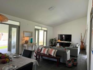 a living room with a couch and a tv at Villa Riacho Doce in Maceió