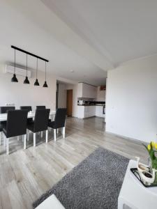 a white living room with a table and chairs at Lighthouse apartment in Nida