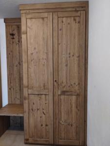 a wooden wardrobe with two doors and a shelf at STOP & STARE STARS in Lignan