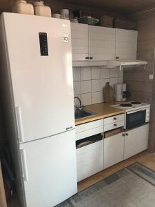 a white refrigerator in a kitchen with white cabinets at Osetunet, small and charming cabin at Ustaoset in Ustaoset