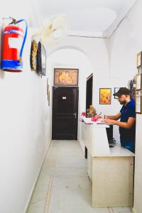 Ein Mann steht an einer Theke in einer Küche in der Unterkunft Roomshala 155 Hotel JPC - Malviya Nagar in Neu-Delhi