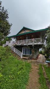 a wooden house with a porch and stairs to it at Shoonya x Aranya Agosh - Letibunga Mukteshwar in Mukteswar