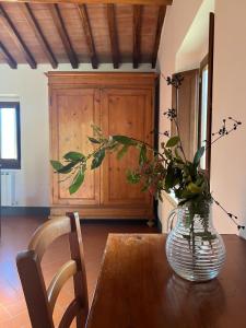 un vaso di fiori seduto su un tavolo di legno di LOCANDA PODERE LE VIGNE a Radda in Chianti