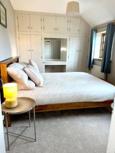 a bedroom with a large bed and a table at Charming Farm based cottage with hot tub and sauna in Newton