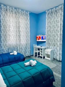 een slaapkamer met 2 bedden, een bureau en een televisie bij B&B Corso Italia in Pisa