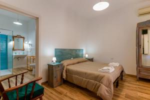 1 dormitorio con 1 cama grande y baño en NonnAdele, en Iglesias