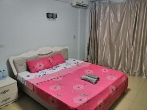 a bedroom with a pink bed with pink pillows at Mariana Shared Home in Dar es Salaam