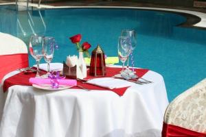 un tavolo con bicchieri da vino e fiori di The Siyona Resort a Ramnagar