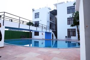 un hotel con piscina frente a un edificio en The Siyona Resort en Rāmnagar