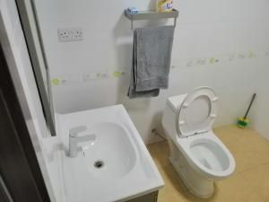 a white bathroom with a toilet and a sink at Mariana Shared Home in Dar es Salaam
