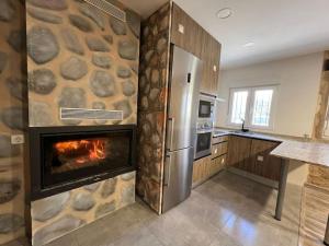 a kitchen with a stone wall with a fireplace at Casa Rural La Atalaya in Montarrón