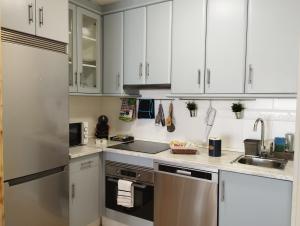 a kitchen with white cabinets and stainless steel appliances at Apartamento Morriña in Brion