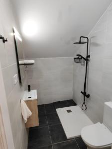 ein weißes Bad mit einem WC und einem Waschbecken in der Unterkunft Somo in Somo