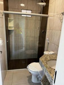 a bathroom with a shower and a toilet and a sink at Vila Diamantina in Mucugê