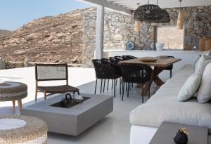 sala de estar con sofá, mesa y sillas en Villa Elia Breeze Mykonos en Mykonos
