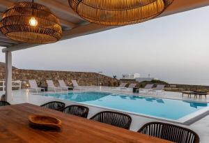 una gran piscina con mesa y sillas en Villa Elia Breeze Mykonos en Mykonos