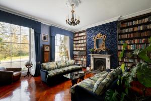 Plas Llangoedmor في كارديغان: غرفة معيشة مع أريكة ومدفأة