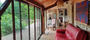 sala de estar con sofá rojo y puertas de cristal en Le petit duc en Gans