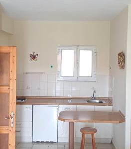 a kitchen with a wooden table and a sink at FLORA STUDIOS CORFU - Adults only in Benitses