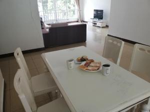a white table and chairs with a plate of food on it at Mariana Shared Home in Dar es Salaam
