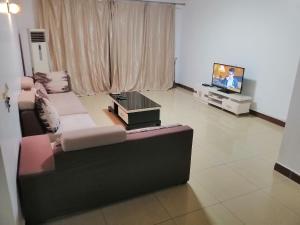a living room with a couch and a tv at Mariana Shared Home in Dar es Salaam