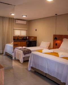 a hotel room with two beds and a table at Vila Diamantina in Mucugê