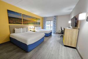 a hotel room with two beds and a flat screen tv at Days Inn by Wyndham Berlin Meriden in Berlin