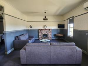 a living room with a couch and a fireplace at Wagga Wagga Country Cottages in Wagga Wagga