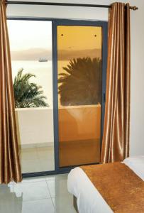 a bedroom with a large window with a view of the ocean at PALM BEACH HOTEL free ticket for pedal boat تذكرة مجانية للالعاب البحرية in Aqaba
