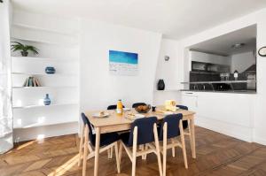 123paris city في باريس: مطبخ وغرفة طعام مع طاولة وكراسي خشبية