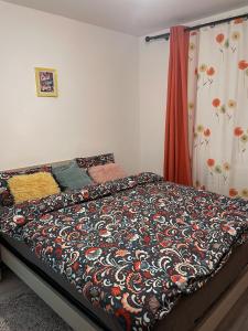 ein Schlafzimmer mit einem Bett mit einer Decke darauf in der Unterkunft Good Vibes Apartment in Câmpulung Moldovenesc + 38 Fotos