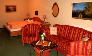 ein Hotelzimmer mit einem Sofa und einem Bett in der Unterkunft Hotel Edelweiss in Fügen