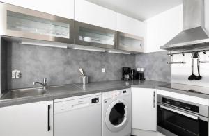 a kitchen with a washing machine and a sink at 123paris city in Paris