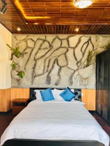 um quarto com uma cama grande e almofadas azuis em Homestay Thác Liên Khương em Ðưc Trọng