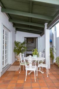 a patio with a table and chairs on a porch at Fig Tree in Pretoria