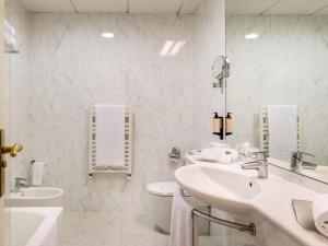 La salle de bains blanche est pourvue de 2 lavabos et de toilettes. dans l'établissement Mercure Carlton Rioja, à Logroño