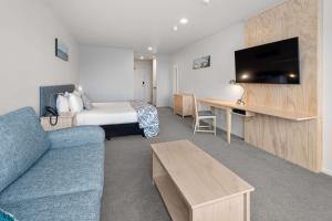 um quarto de hotel com uma cama e um sofá em Quality Hotel Oceans Tutukaka em Tutukaka
