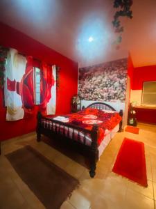 a red bedroom with a bed with a painting on the wall at Rose bungalow at Ya Nui beach in Nai Harn Beach