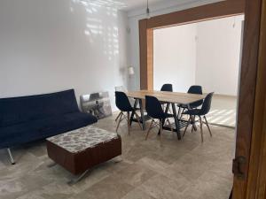 ein Wohnzimmer mit einem blauen Sofa, einem Tisch und Stühlen in der Unterkunft Stelarium-Übica2 Guesthouse in Mairena del Aljarafe