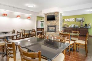 a restaurant with tables and chairs and a fireplace at Sleep Inn in Hickory