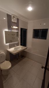 ein Badezimmer mit einem Waschbecken, einer Badewanne und einem WC in der Unterkunft The Bayt in Srinagar