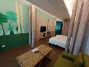 1 dormitorio con cama, mesa y sofá en 三条文旅, en Kaohsiung