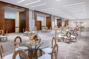 Al Andalus Mall Hotel في جدة: قاعة احتفالات مع طاولات وكراسي مع ورود