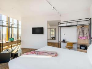 a bedroom with a large white bed and a tv at ibis Budapest Stadium in Budapest