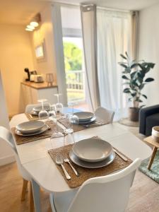 a dining room table with plates and silverware on it at Appartement Cosy - Cap d'Agde proche plage et port - Parking in Cap d'Agde