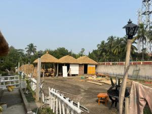 ein im Bau befindliches Haus mit einem Zaun und einer Straßenbeleuchtung in der Unterkunft Tapama Resort in Bakkhali