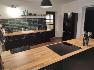 eine Küche mit einer Holztheke und einem schwarzen Kühlschrank in der Unterkunft Logement Spacieux in Fraize