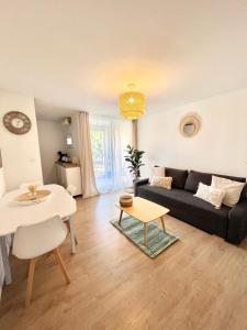a living room with a couch and a table at Appartement Cosy - Cap d'Agde proche plage et port - Parking in Cap d'Agde