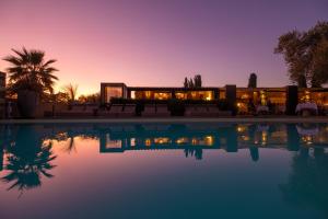a house with a swimming pool at sunset at Hôtel La Dimora & Spa in Oletta
